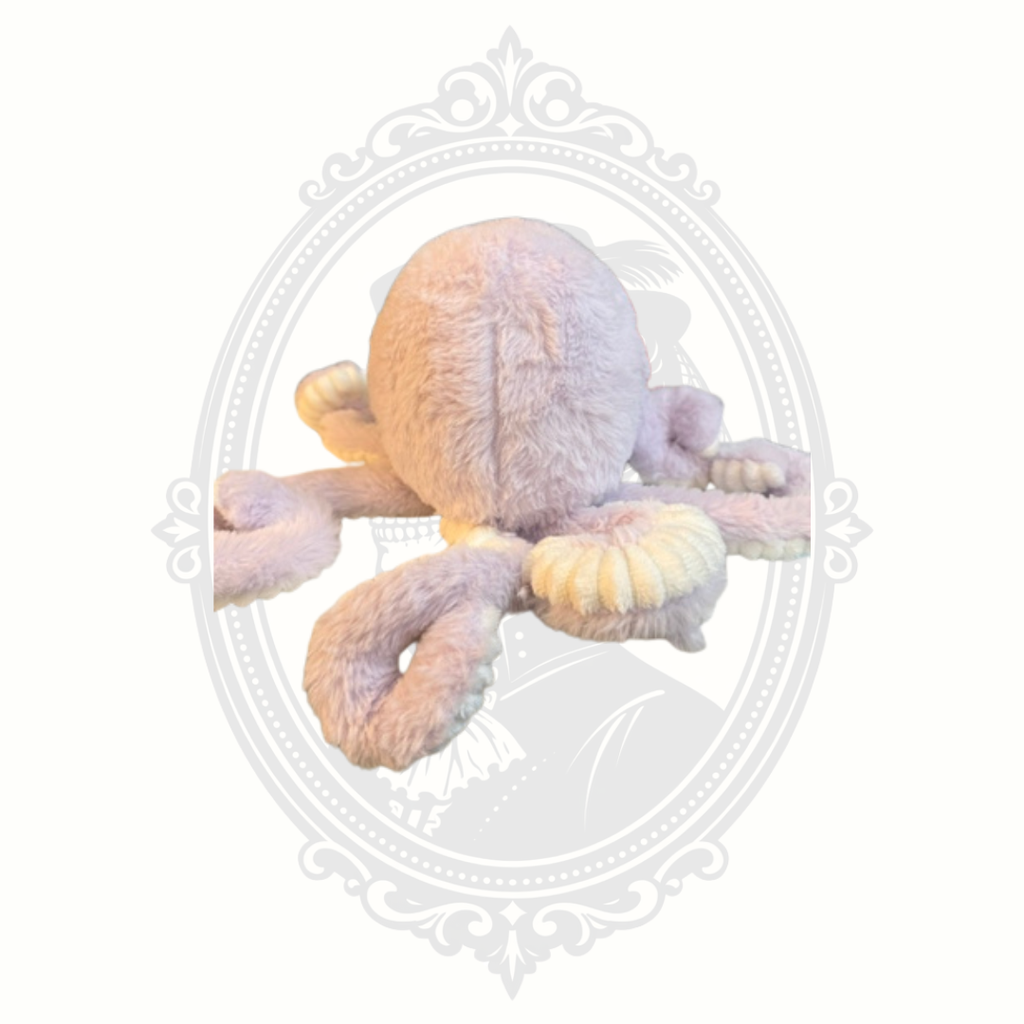 Soft pastel octopus plush toy with embroidered face and textured tentacles.