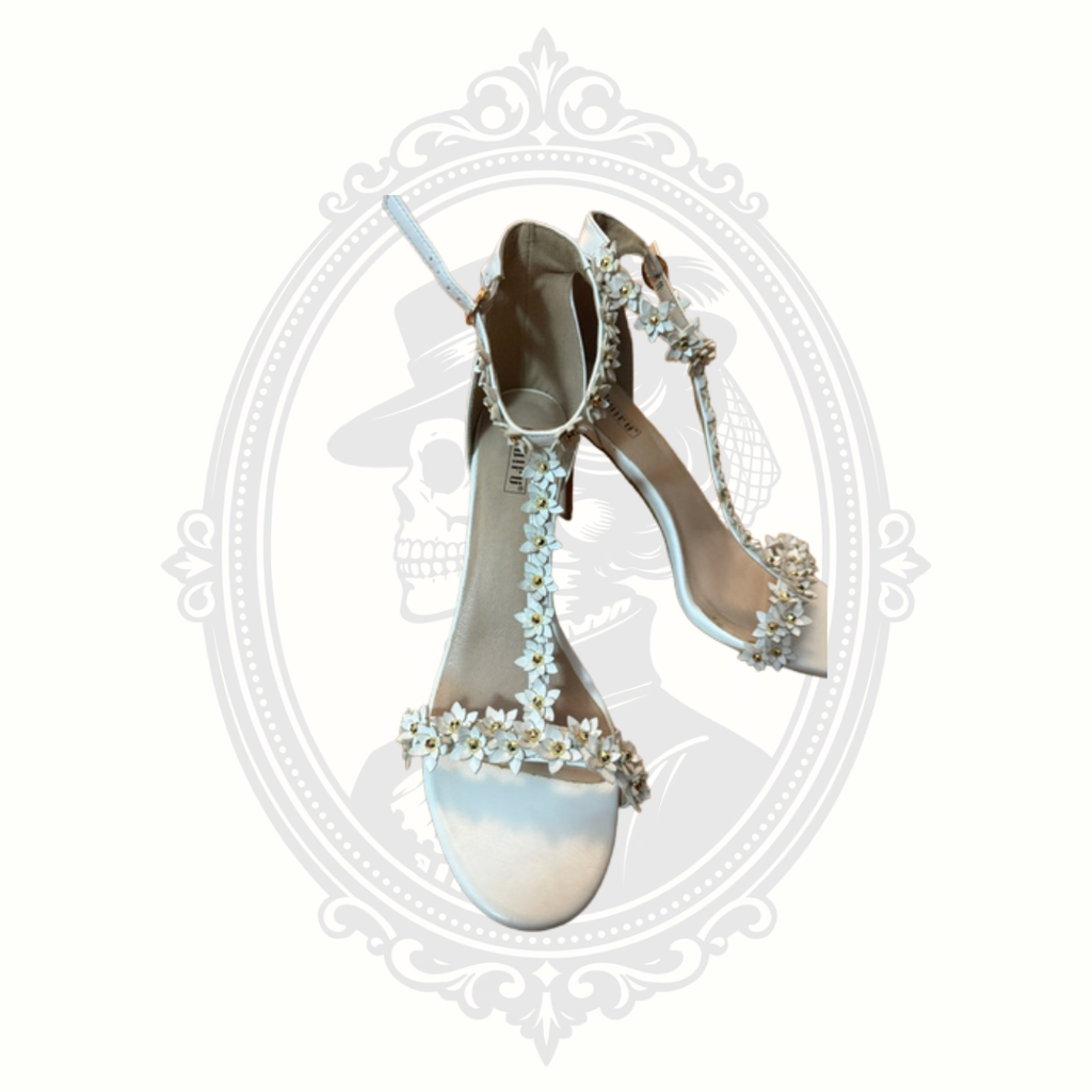 Closeup detail of white floral appliqué straps on DIDIFU women’s statement heels.