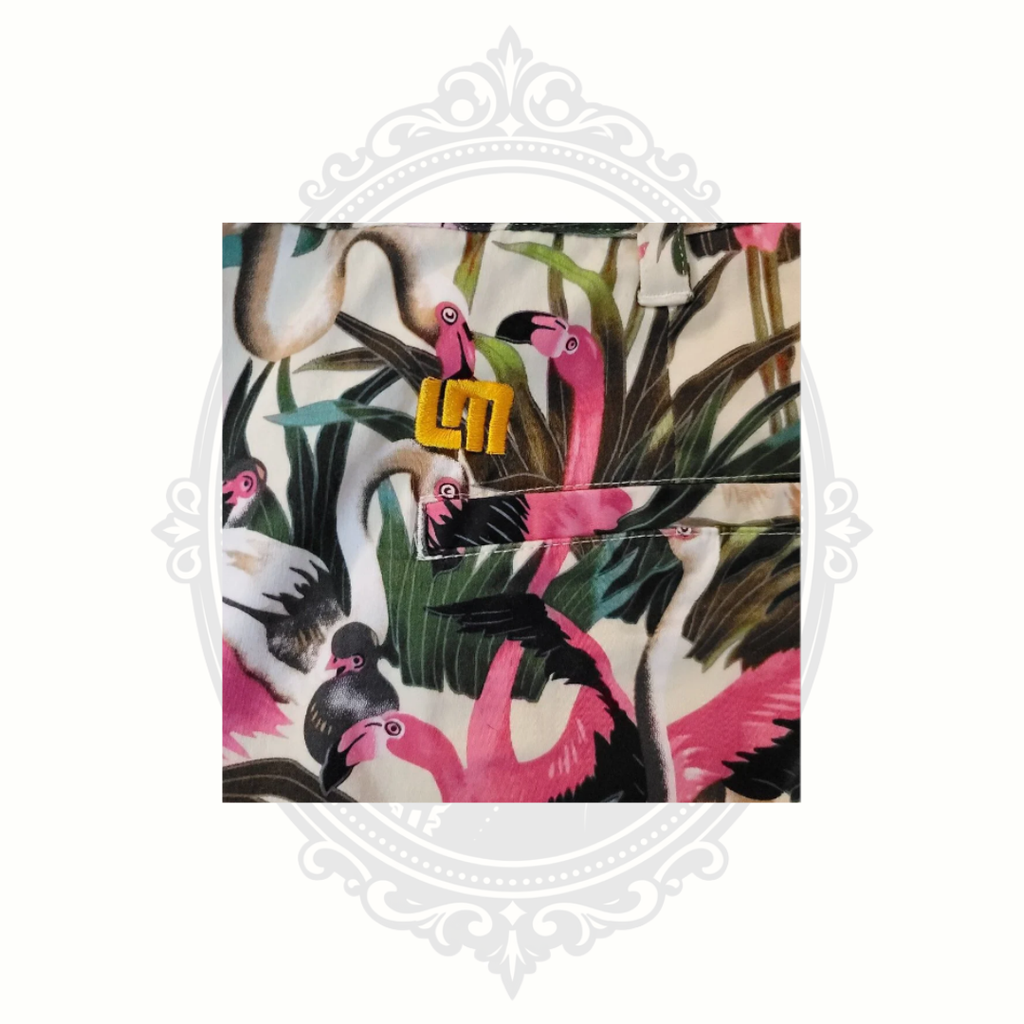 Close-up detail of Loudmouth logo and flamingo tropical print fabric with pink flamingos and palm leaves