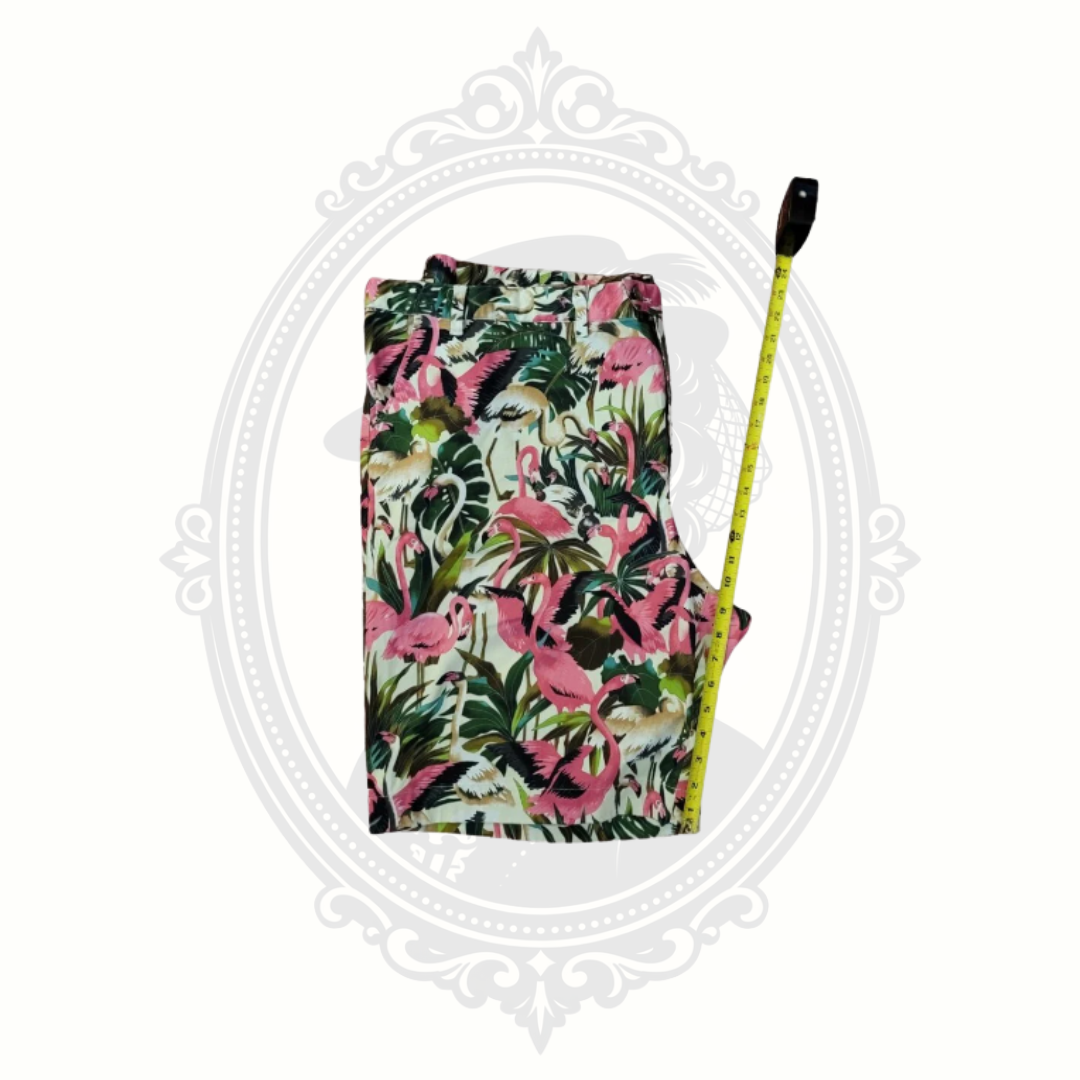 Floral fabric with pink flamingos and green leaves, measured with a tape measure on a white background.