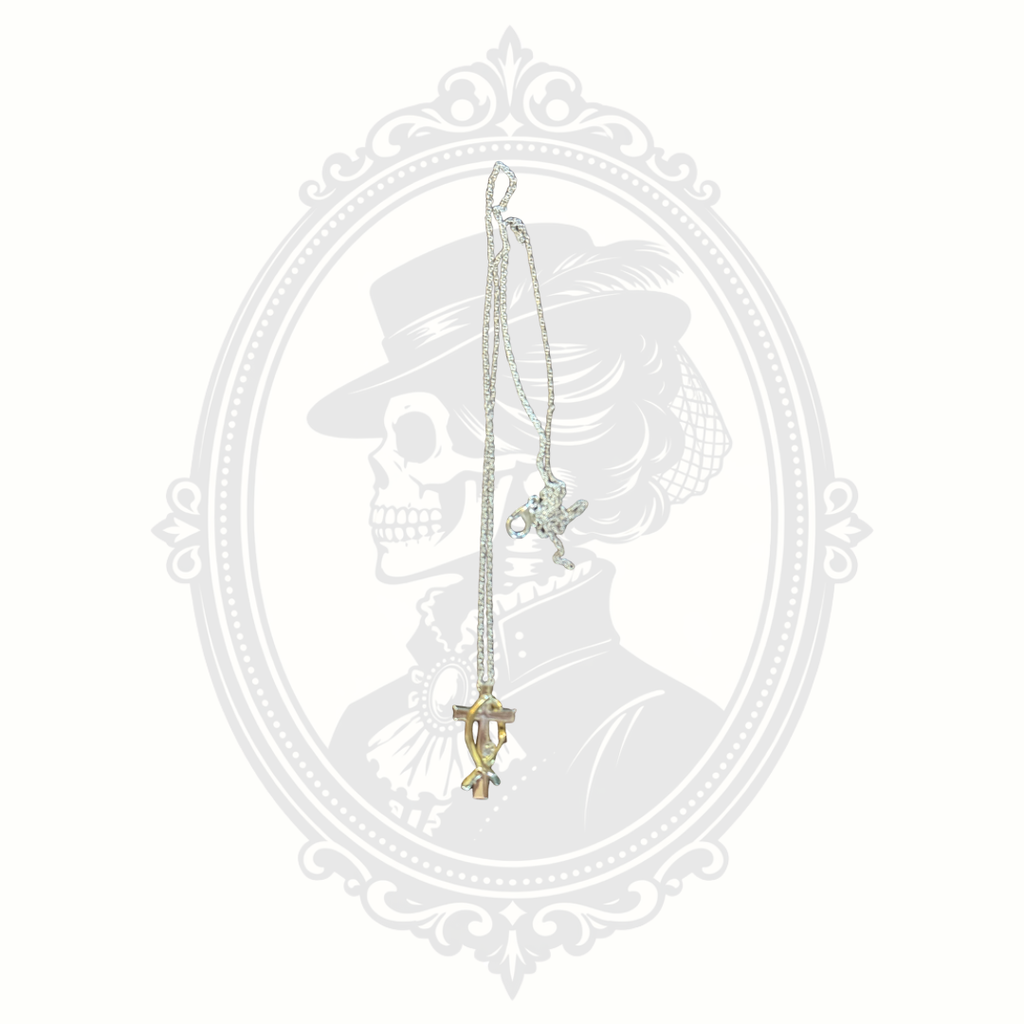 Silver-tone necklace featuring a two-tone crystal cross pendant from the Melanie Jewelry Collection displayed against a Mrs. Bones Boutique background.