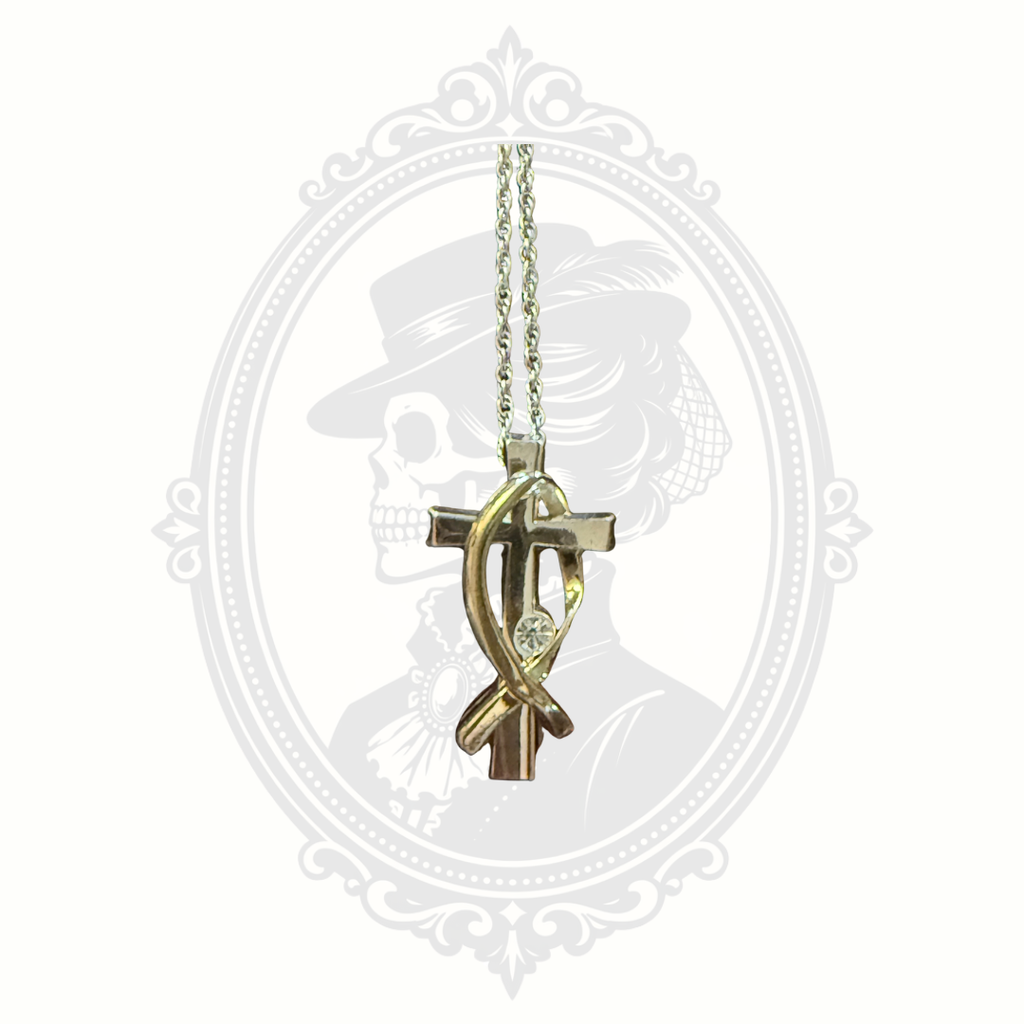 Close-up detail of two-tone cross pendant with crystal accent from the Melanie Jewelry Collection.