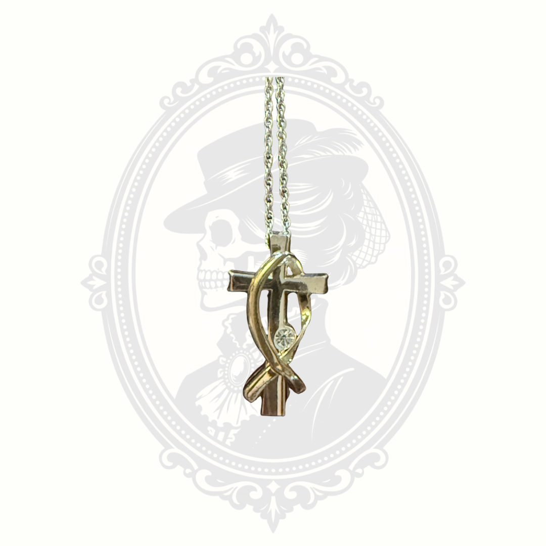 Close-up detail of two-tone cross pendant with crystal accent from the Melanie Jewelry Collection.