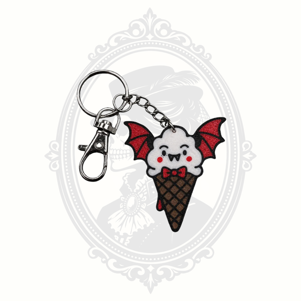 Battie Cream keychain featuring a smiling white ice cream scoop with vampire fangs, red bat wings, waffle cone, metal keyring, and lobster clasp.