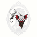 Battie Cream keychain featuring a smiling white ice cream scoop with vampire fangs, red bat wings, waffle cone, metal keyring, and lobster clasp.