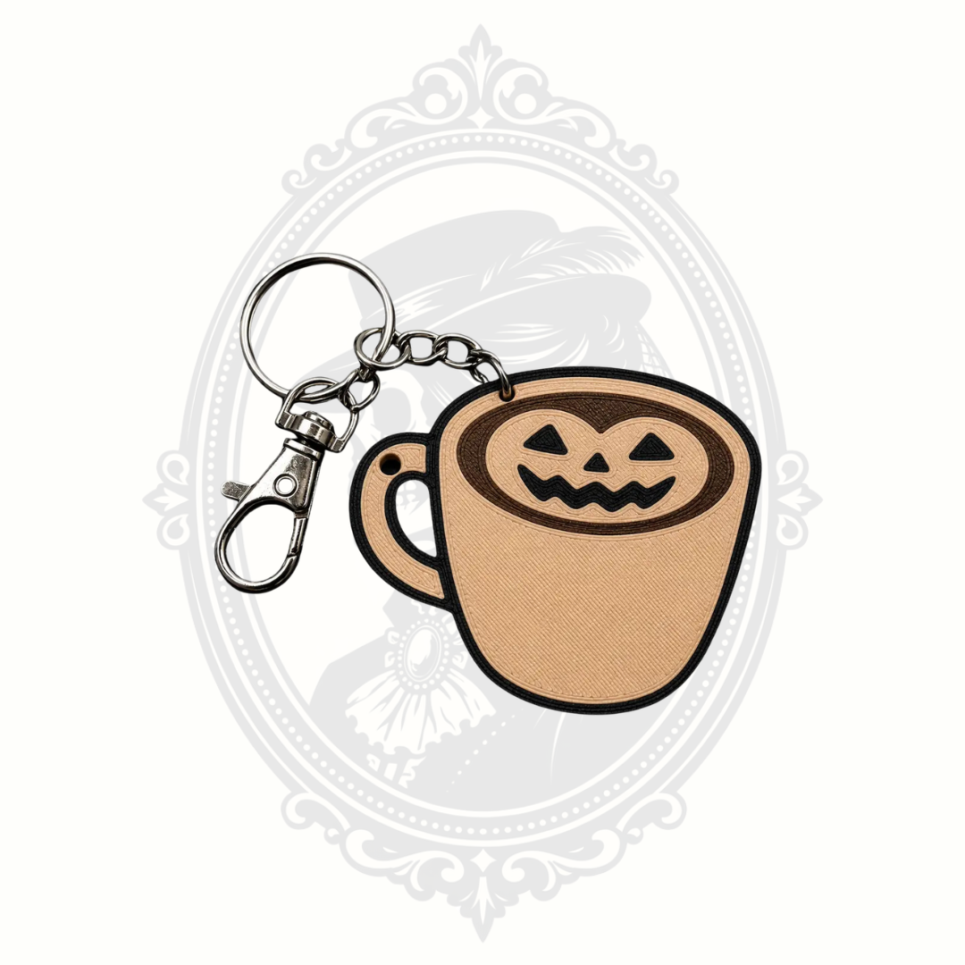 Pumpkin Spice Coffee Cup Halloween keychain featuring a beige coffee mug topped with jack-o'-lantern pumpkin latte art, complete with a metal keyring and lobster clasp.