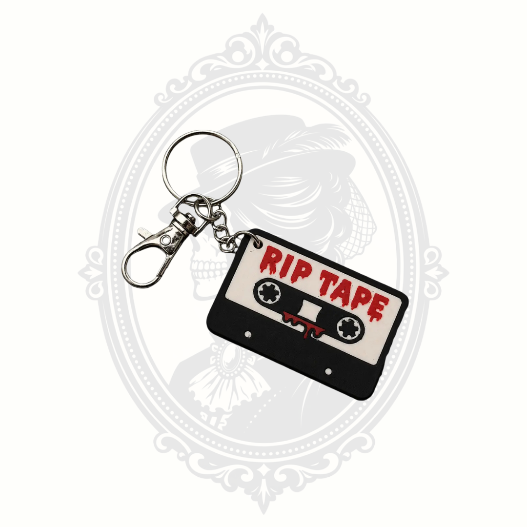 RIP Tape keychain featuring a black and white retro cassette tape with dripping red "RIP TAPE" lettering, metal keyring, and lobster clasp.