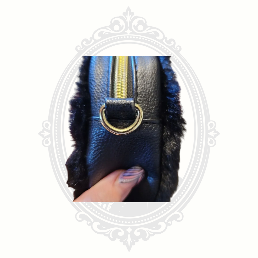 Side angle view of Betsey Johnson troll crossbody bag with adjustable strap and metallic accents.