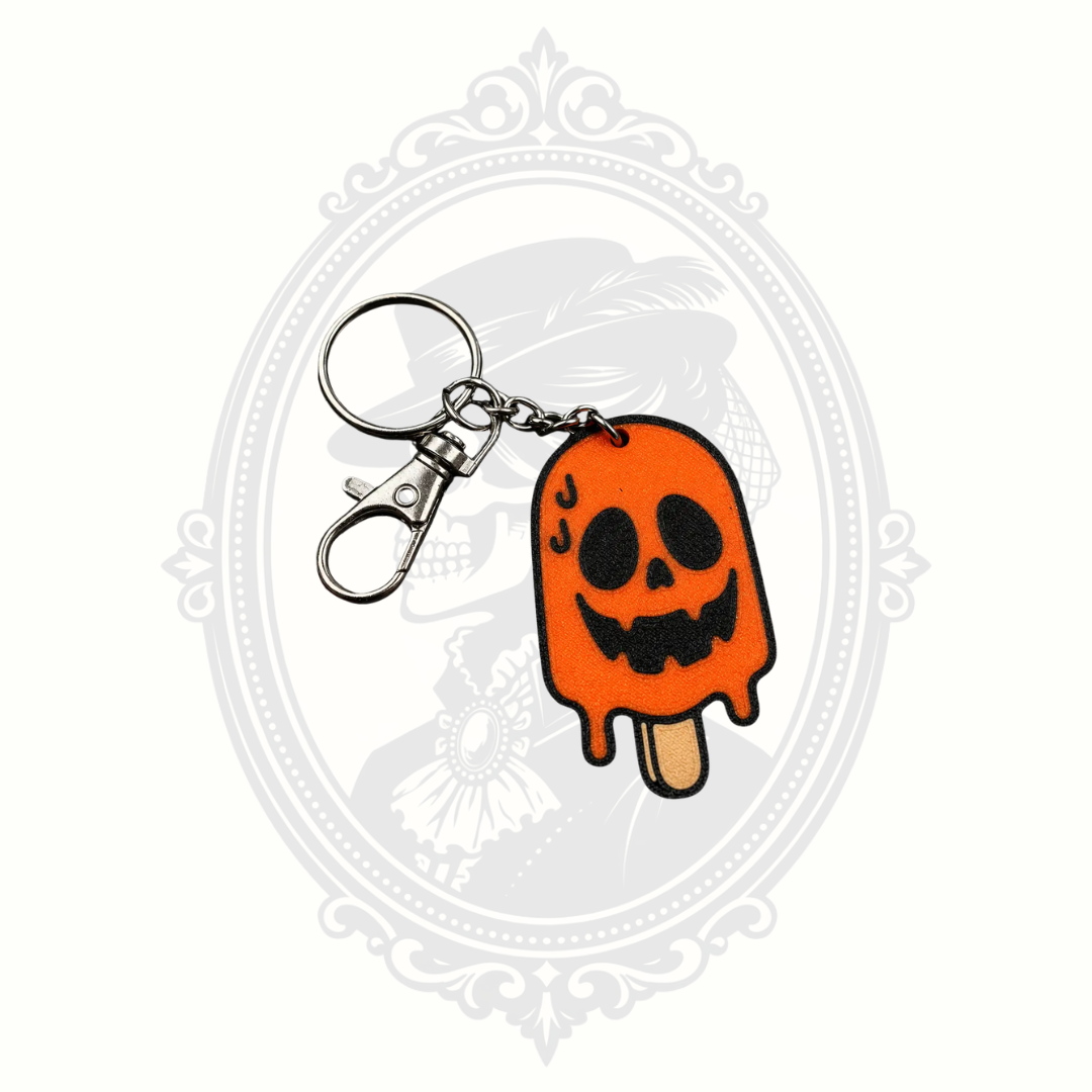 Jack Melting Pop Halloween keychain featuring a melting orange jack-o'-lantern popsicle with a smiling black pumpkin face, metal keyring, and lobster clasp.