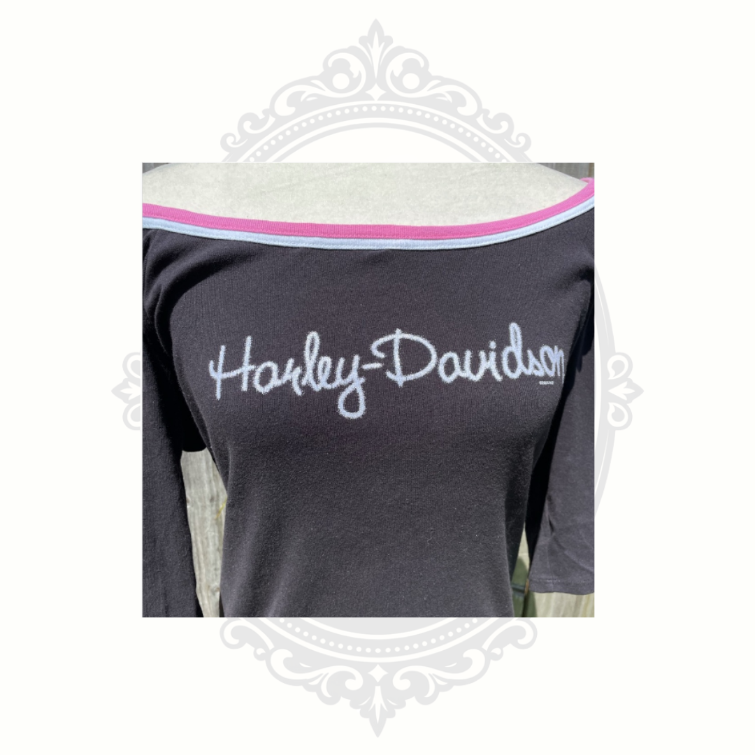 Close-up detail of Harley-Davidson Y2K pink graphic design on black tank top fabric.