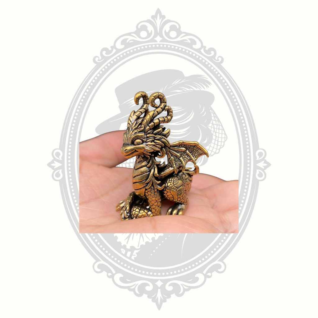 Mini brass dragon figurine shown in hand for scale.