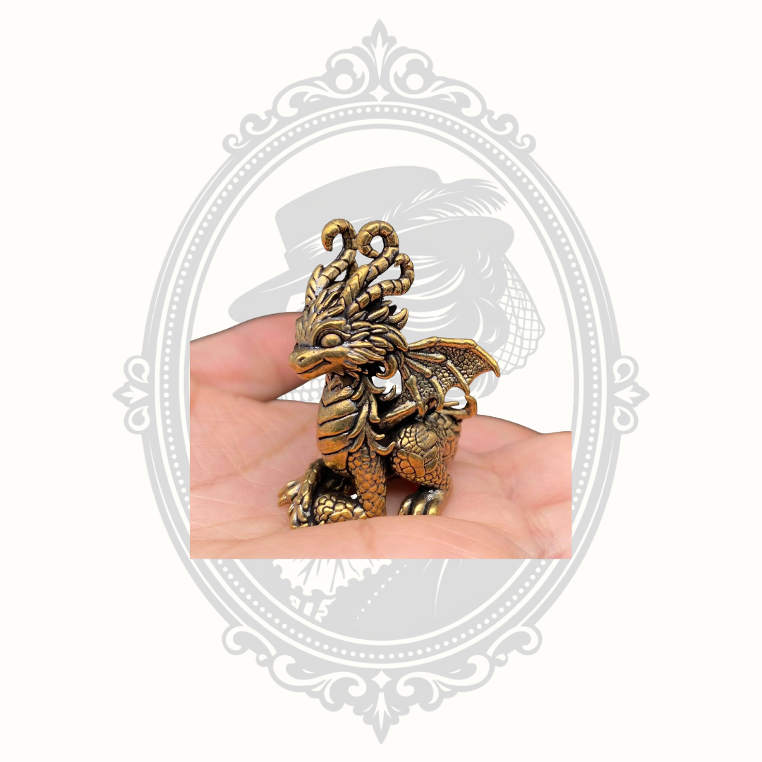 Mini brass dragon figurine shown in hand for scale.