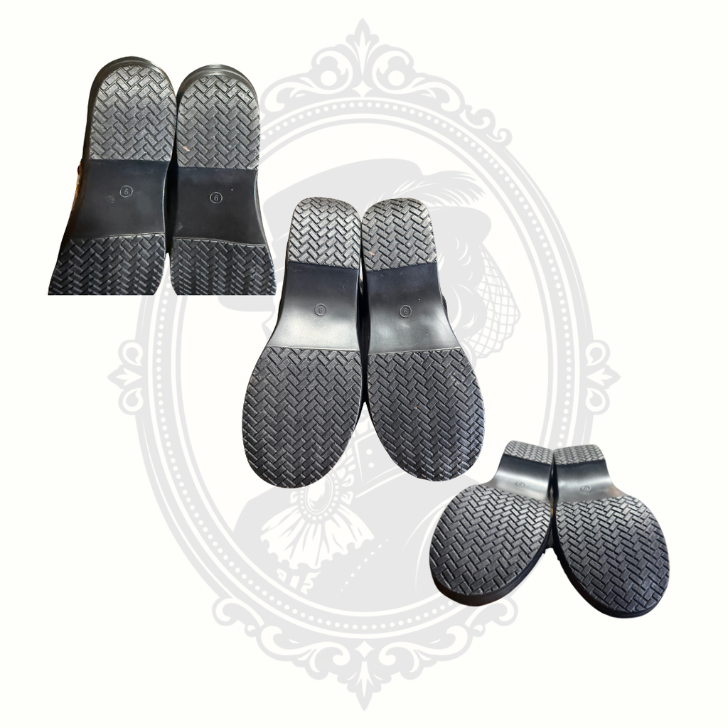 Bottom soles of black salon-themed slip-on shoes showing very clean tread and minimal wear.