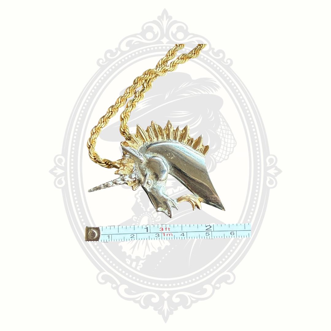 Decorative pendant with gold chain on a white background with measurement tape