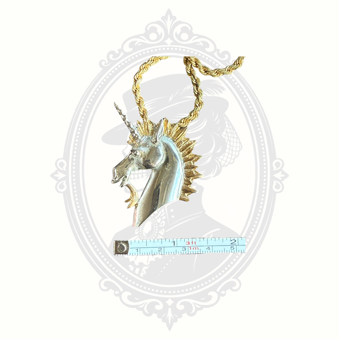 Unicorn-shaped pendant with gold accents on a white background with measurement tape
