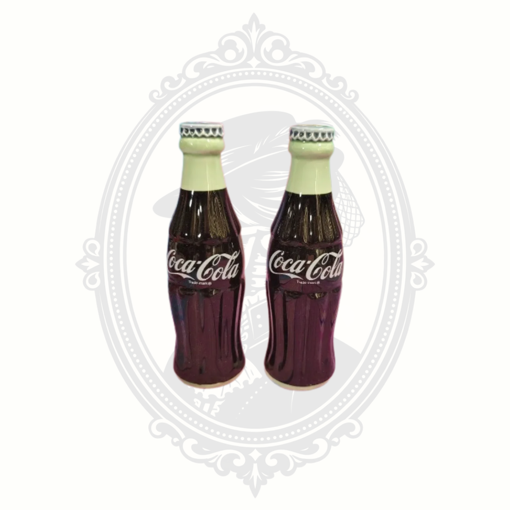 Vintage 1996 Coca-Cola ceramic salt and pepper shakers shaped like classic Coke bottles displayed against a light background.