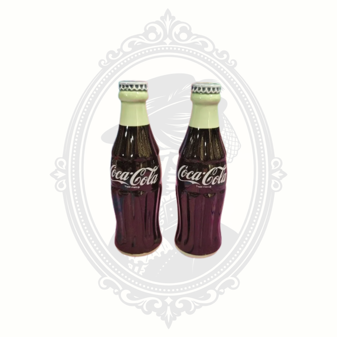 Vintage 1996 Coca-Cola ceramic salt and pepper shakers shaped like classic Coke bottles displayed against a light background.