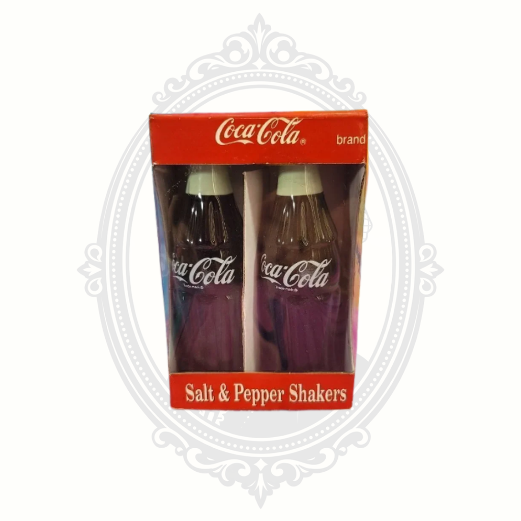 Vintage 1996 Coca-Cola ceramic salt and pepper shaker set in original red Coca-Cola branded box with bottle-shaped shaker design.