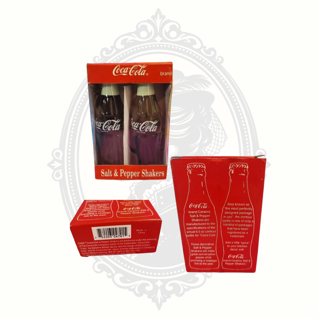 Vintage 1996 Coca-Cola ceramic salt and pepper shaker set displayed with original red packaging showing front, back, and barcode details.