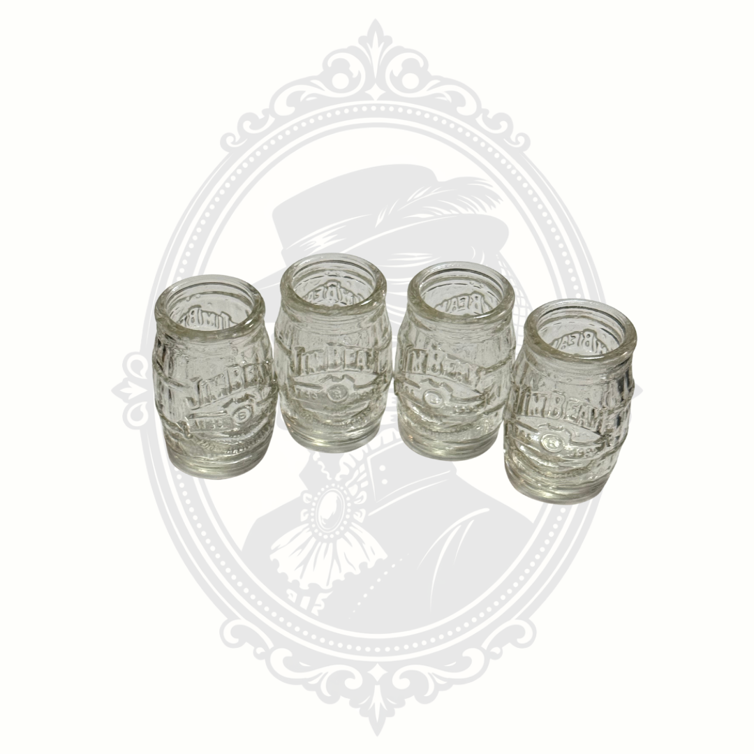 Angled view of four collectible Jim Beam barrel-style shot glasses made of clear embossed glass.