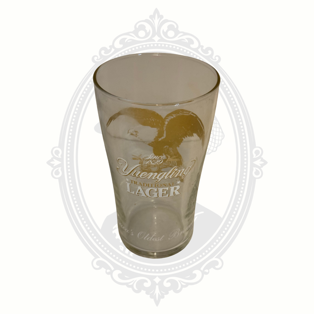 Clear Yuengling Traditional Lager pint glass featuring gold eagle logo artwork photographed against a white background.