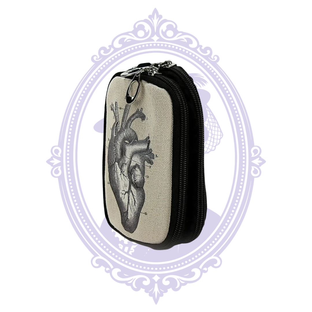 Angled view of anatomical heart canvas wristlet showing zipper compartments