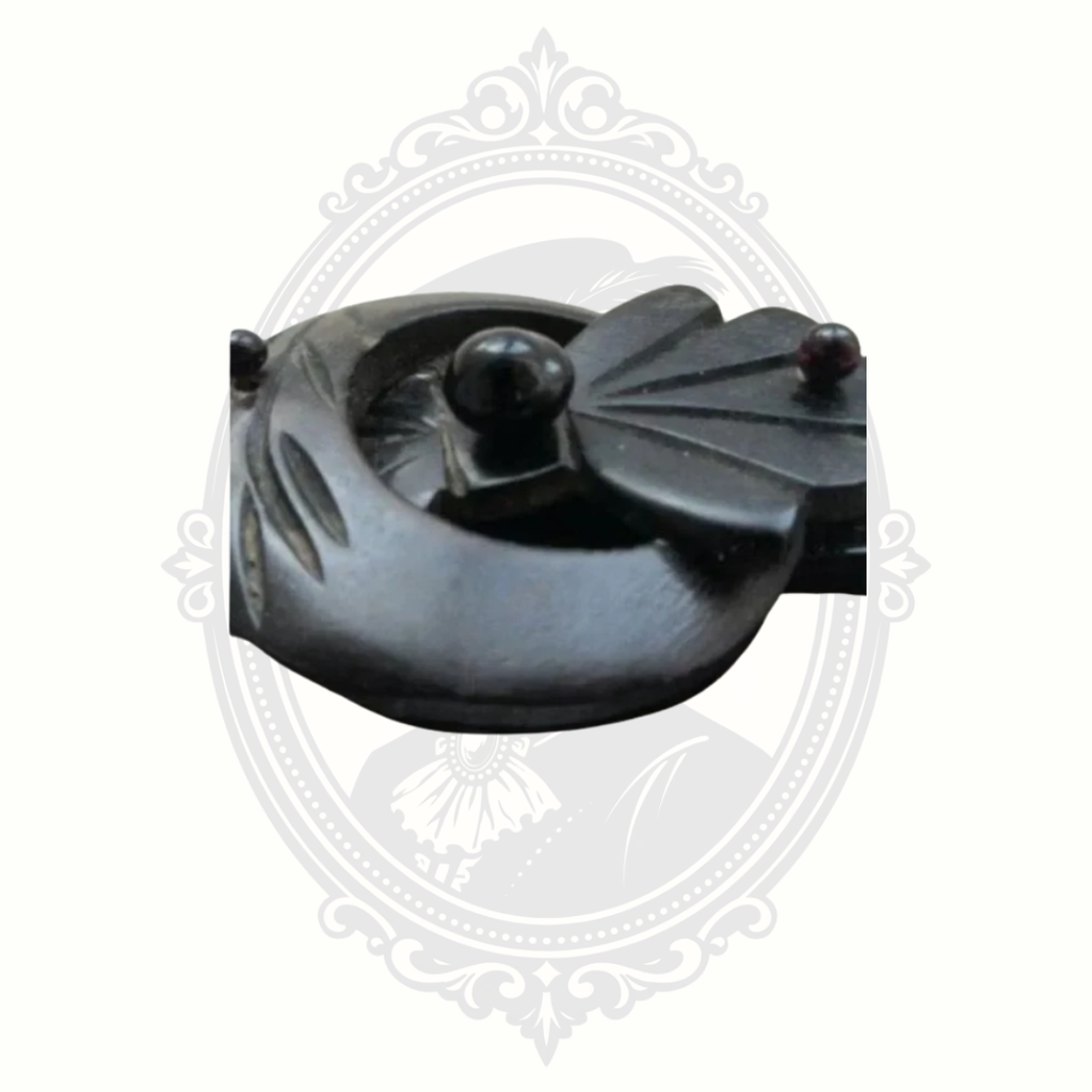 Macro view of antique Victorian mourning brooch surface carvings in black gutta percha with aged patina