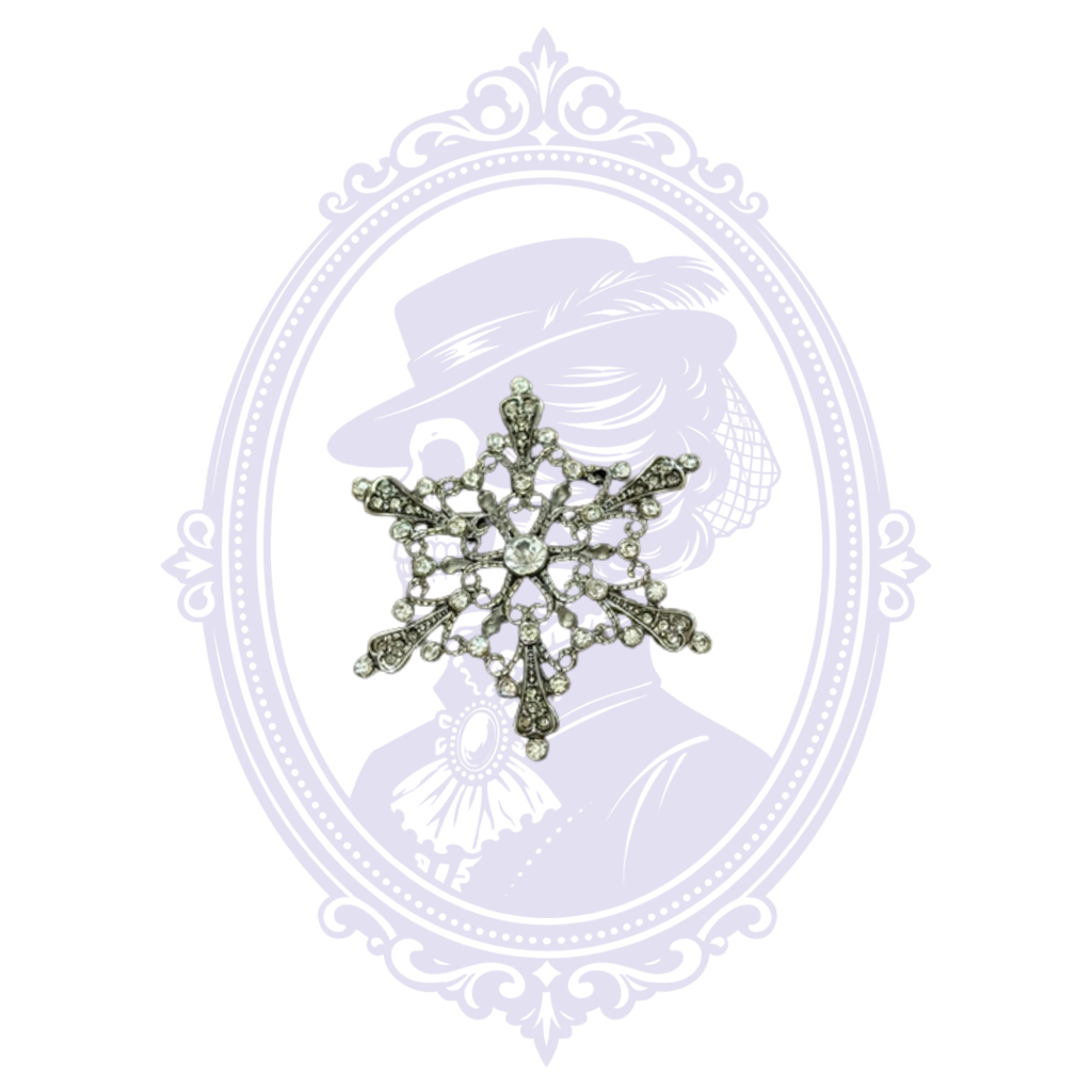 Antiqued silver-tone snowflake brooch with ornate openwork detailing and clear rhinestones.