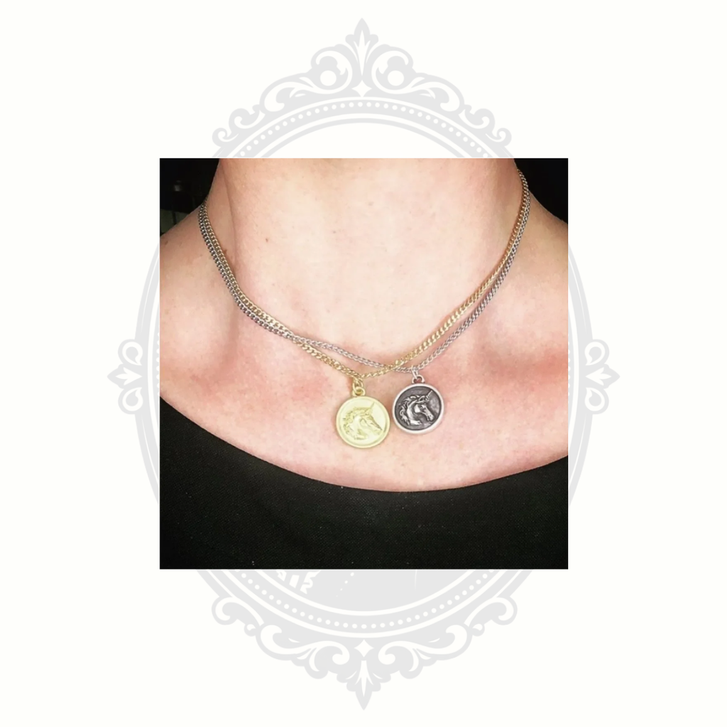 Silver unicorn pendant necklace worn layered with another necklace