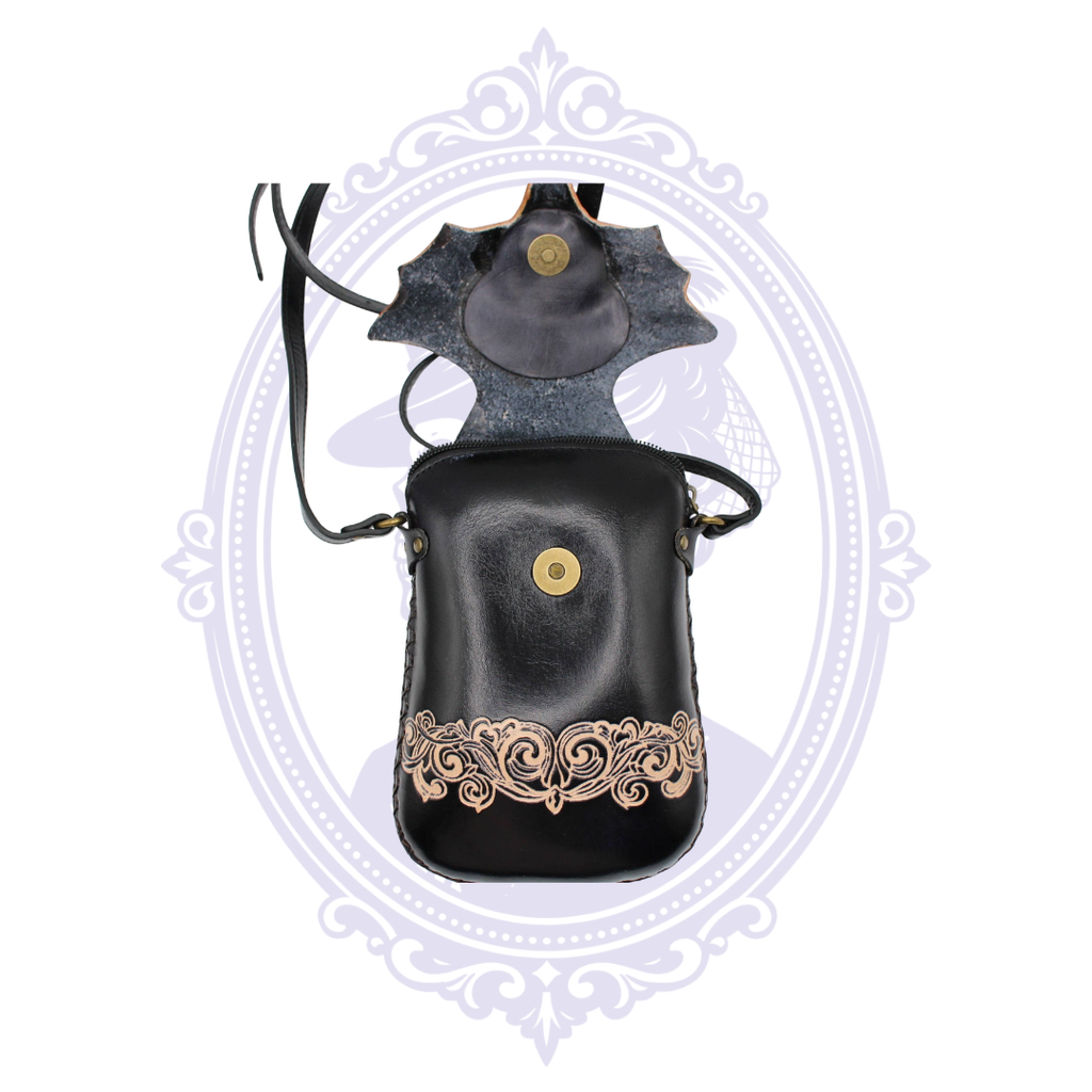 Black leather bat crossbody bag open to show snap closure and interior opening