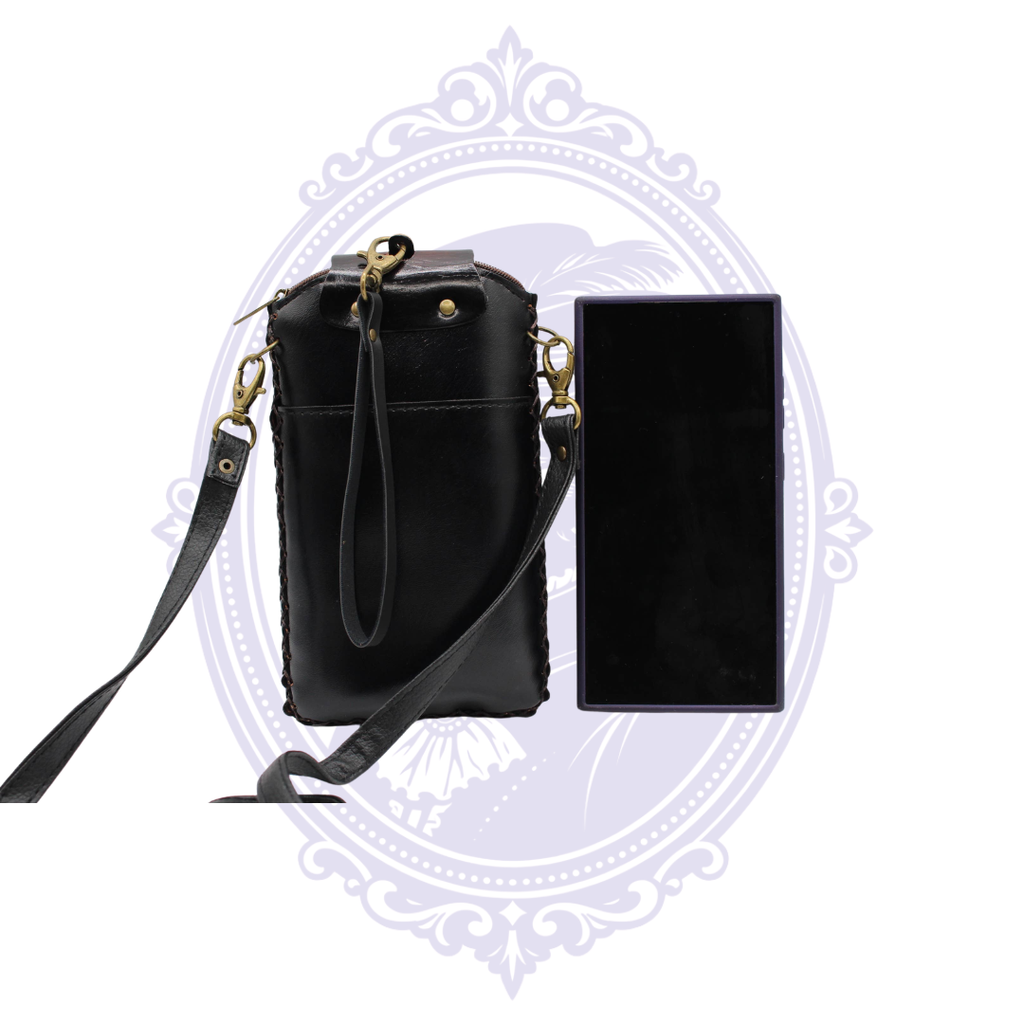 Back view of black leather sugar skull cell phone crossbody holder showing exterior pocket, detachable straps and size reference.