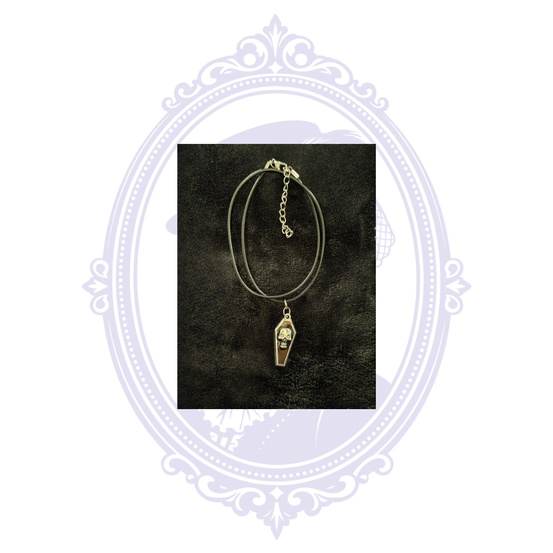 Black coffin pendant necklace with raised silver-tone skull and adjustable black cord.