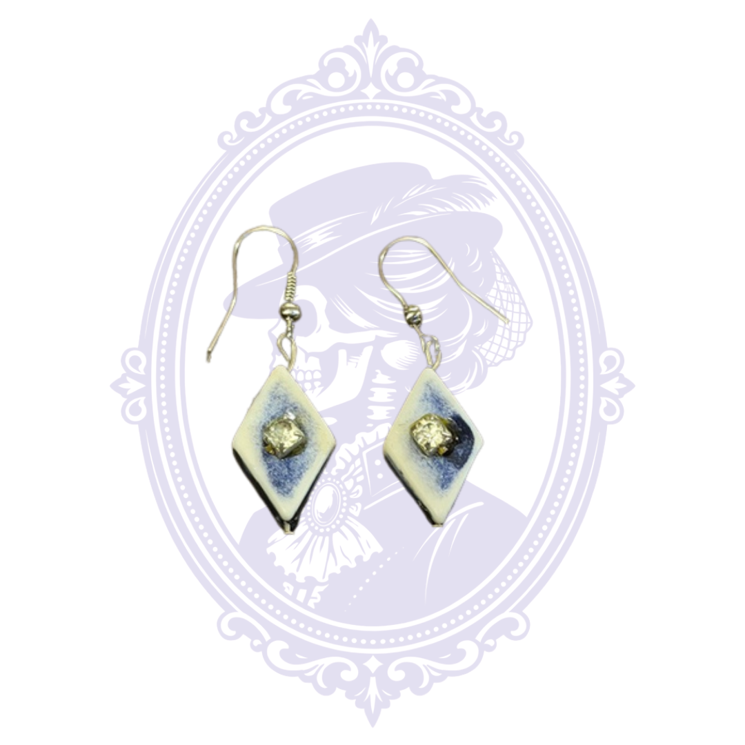 Angled view of blue and white diamond-shaped earrings showing the raised clear rhinestone center accents.