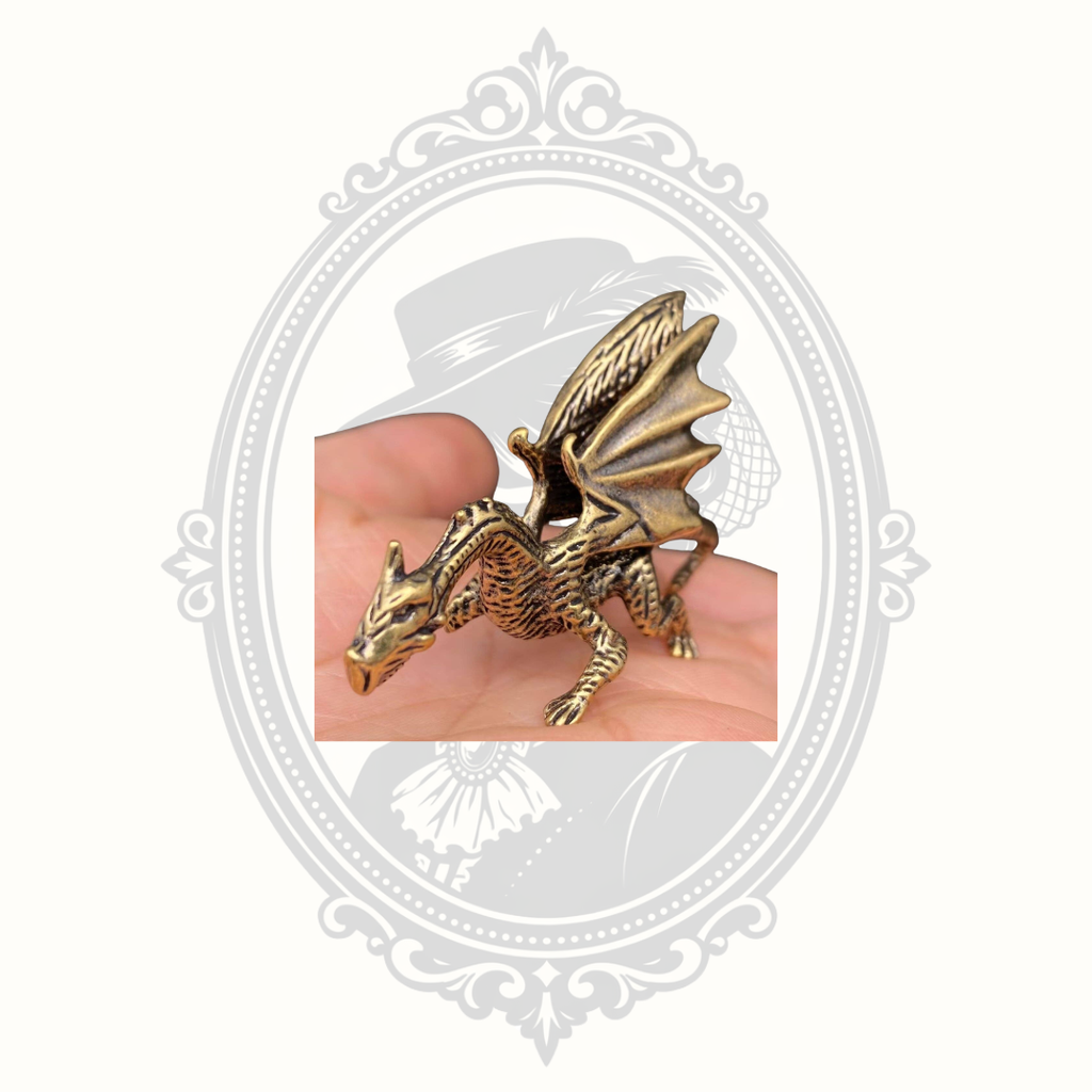 Miniature solid brass dragon ornament displayed in the palm of a hand to demonstrate scale.