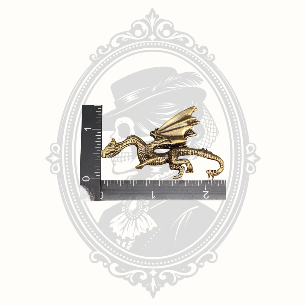 Brass dragon ornament shown beside a ruler for size reference.