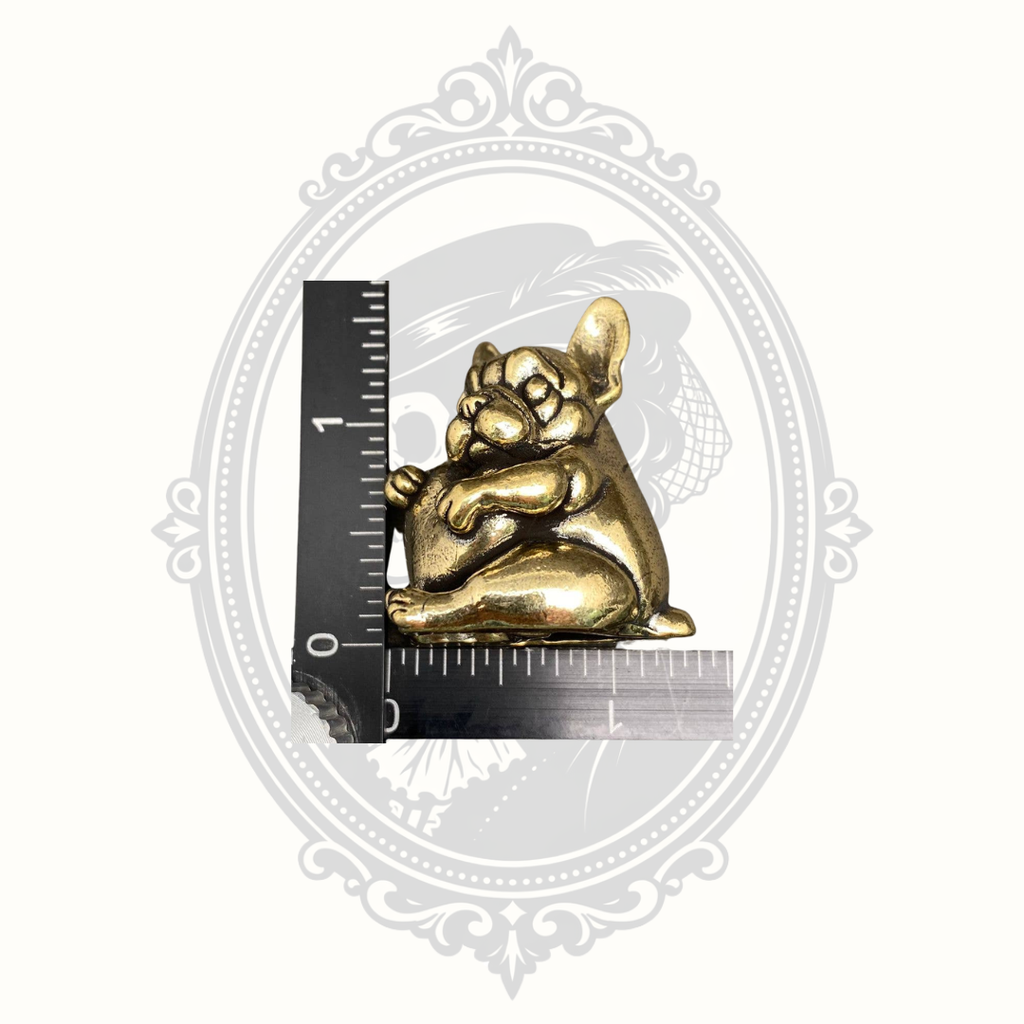 Miniature solid brass French Bulldog heart figurine shown beside a ruler for size reference.