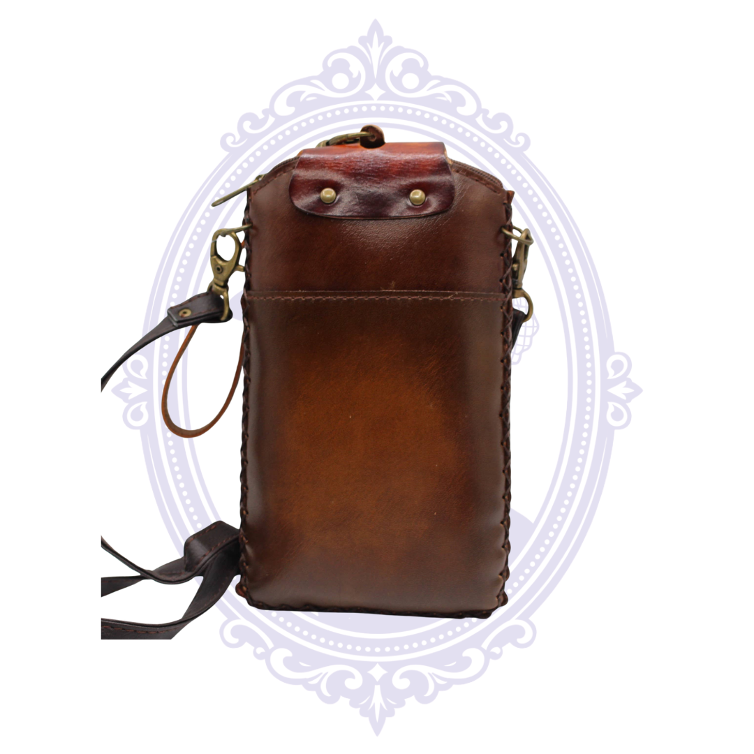 Back view of brown leather sugar skull cell phone crossbody holder showing exterior slip pocket and removable strap hardware.