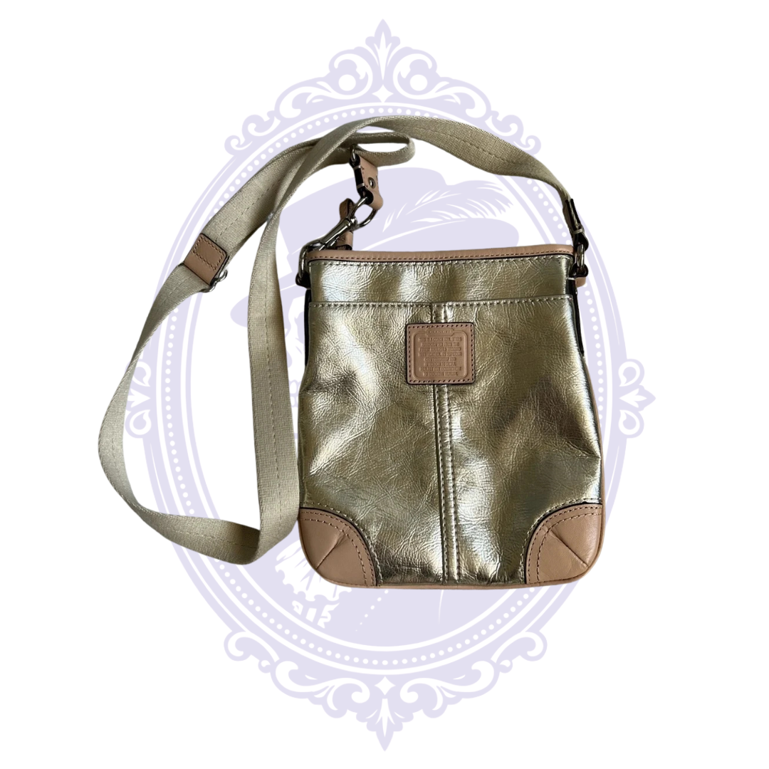 Coach metallic gold leather crossbody bag with tan leather trim, adjustable canvas strap and embossed Coach creed patch.