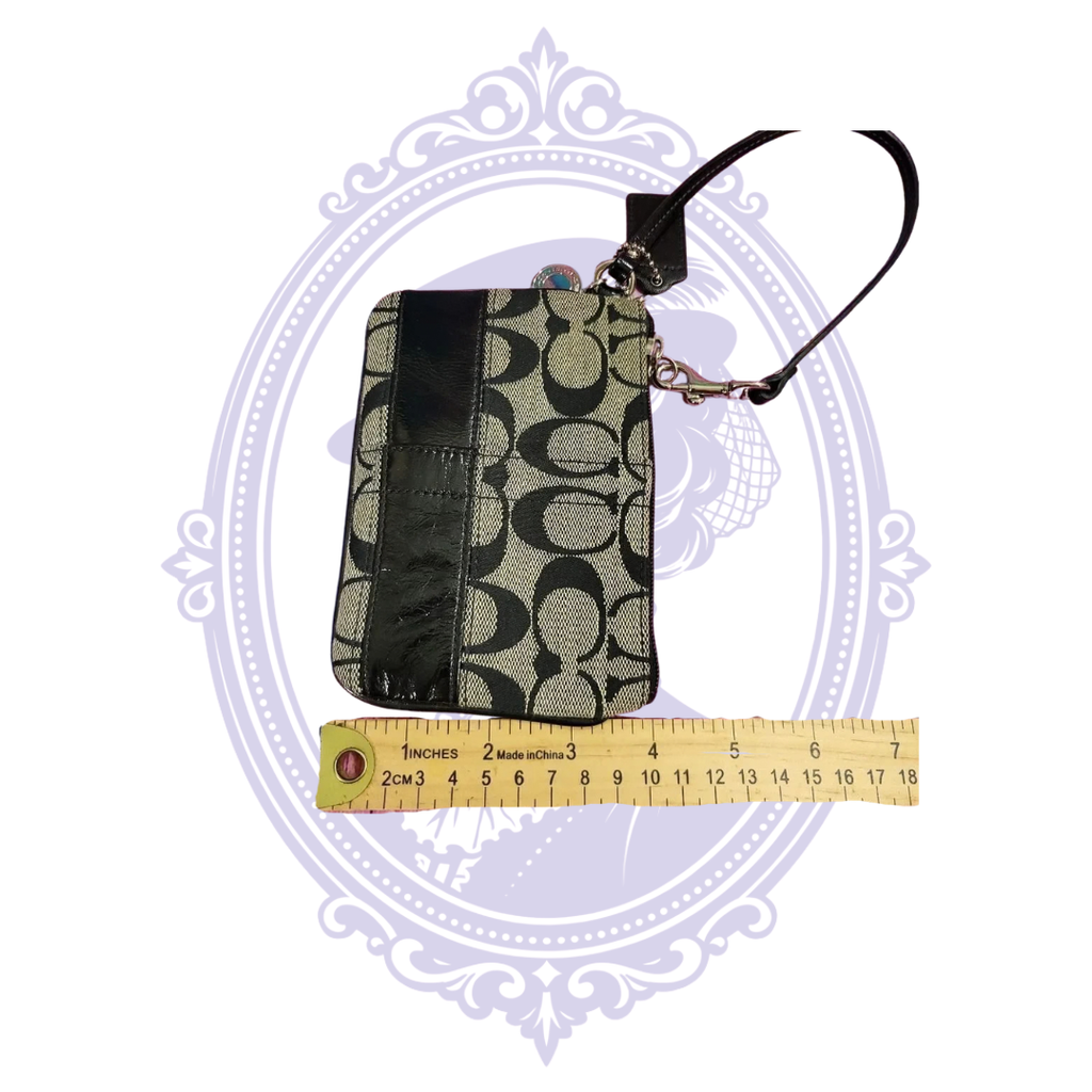 Coach wristlet photographed alongside measuring ruler showing approximate width