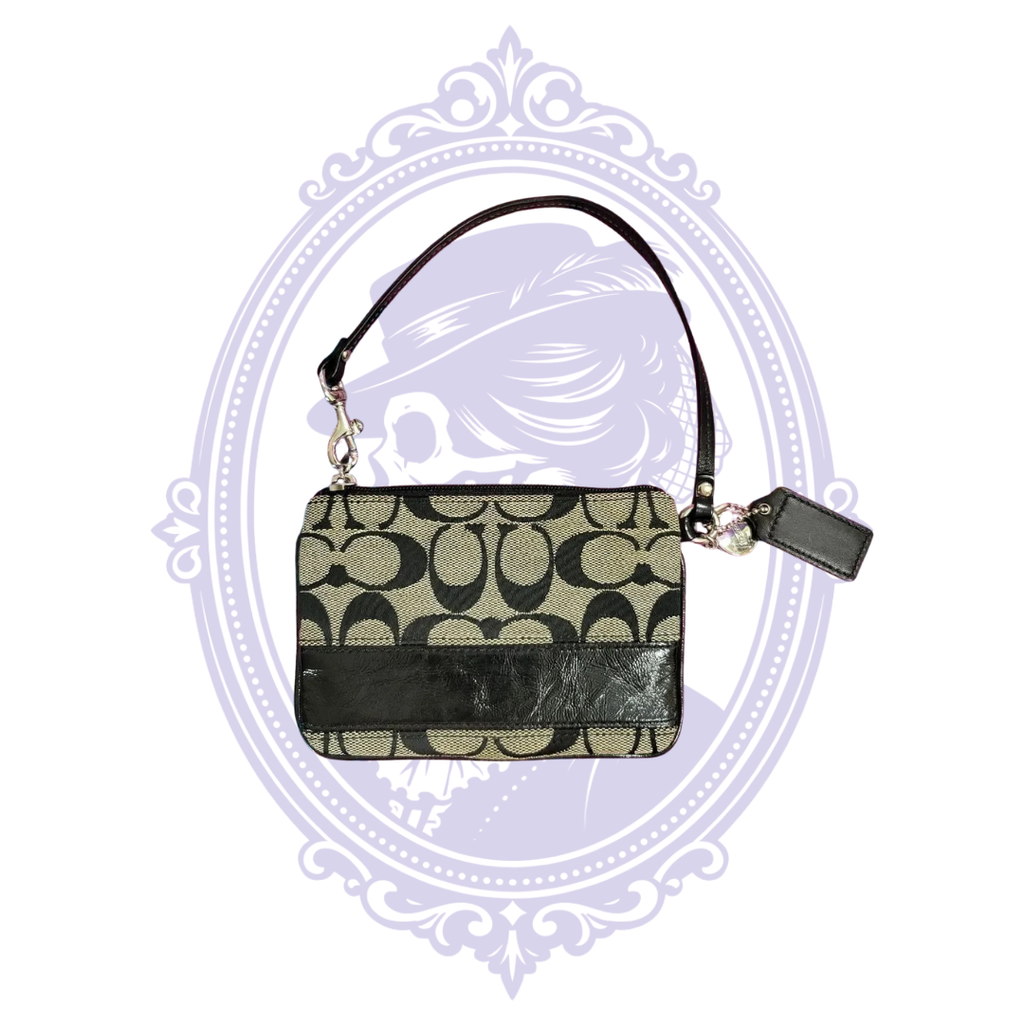 Reverse of Coach black and tan signature jacquard wristlet with black leather trim