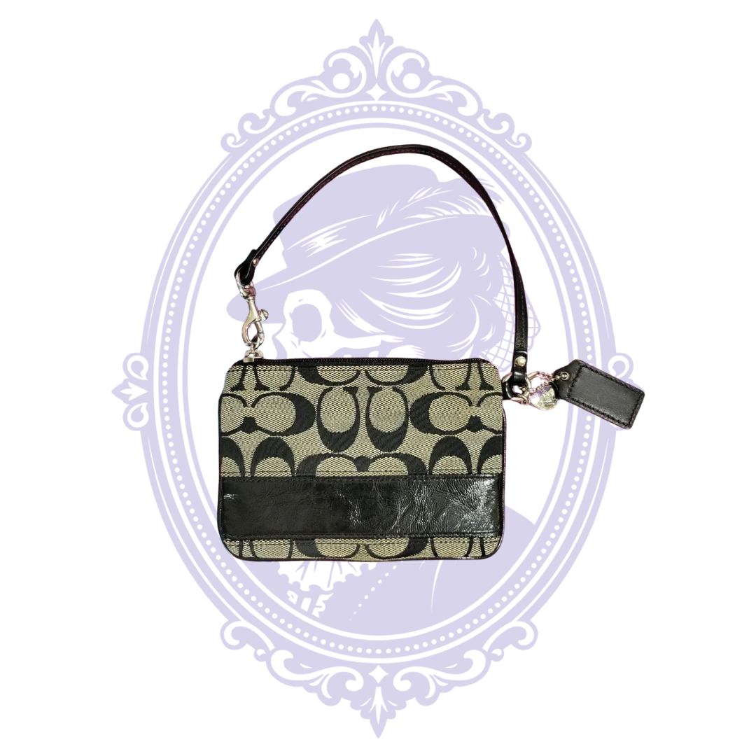 Reverse of Coach black and tan signature jacquard wristlet with black leather trim