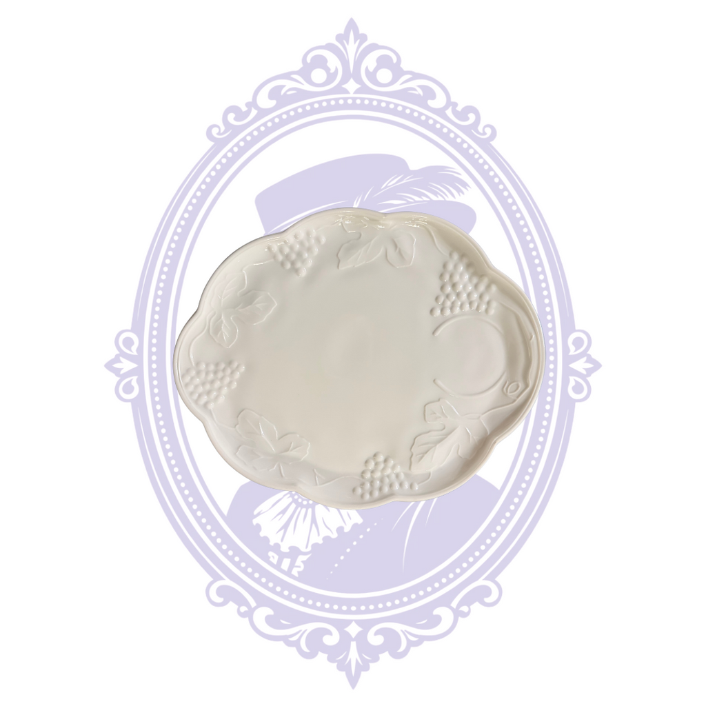 Underside of white milk glass openwork undertray showing recessed base, pierced border, and handles.