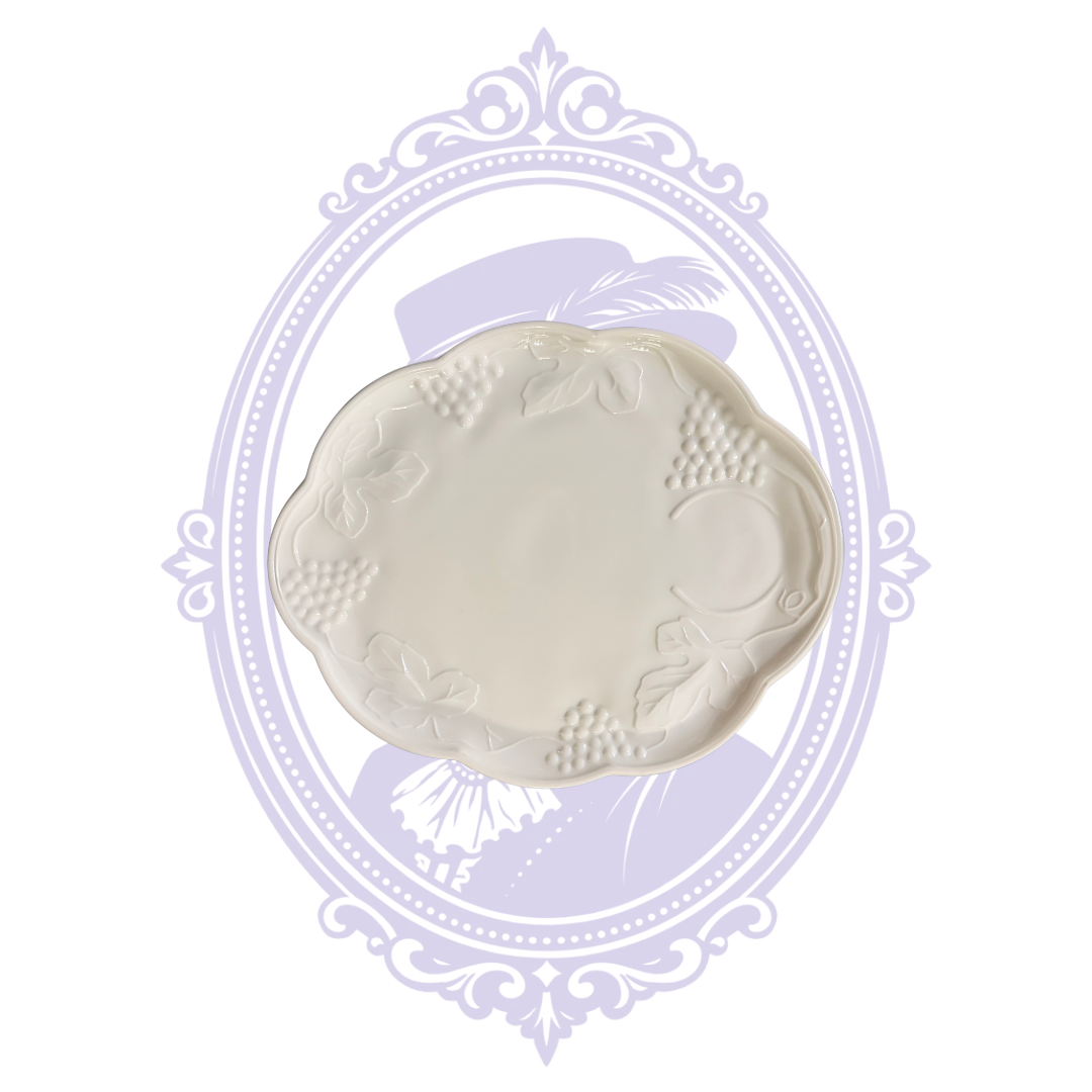 Underside of white milk glass openwork undertray showing recessed base, pierced border, and handles.