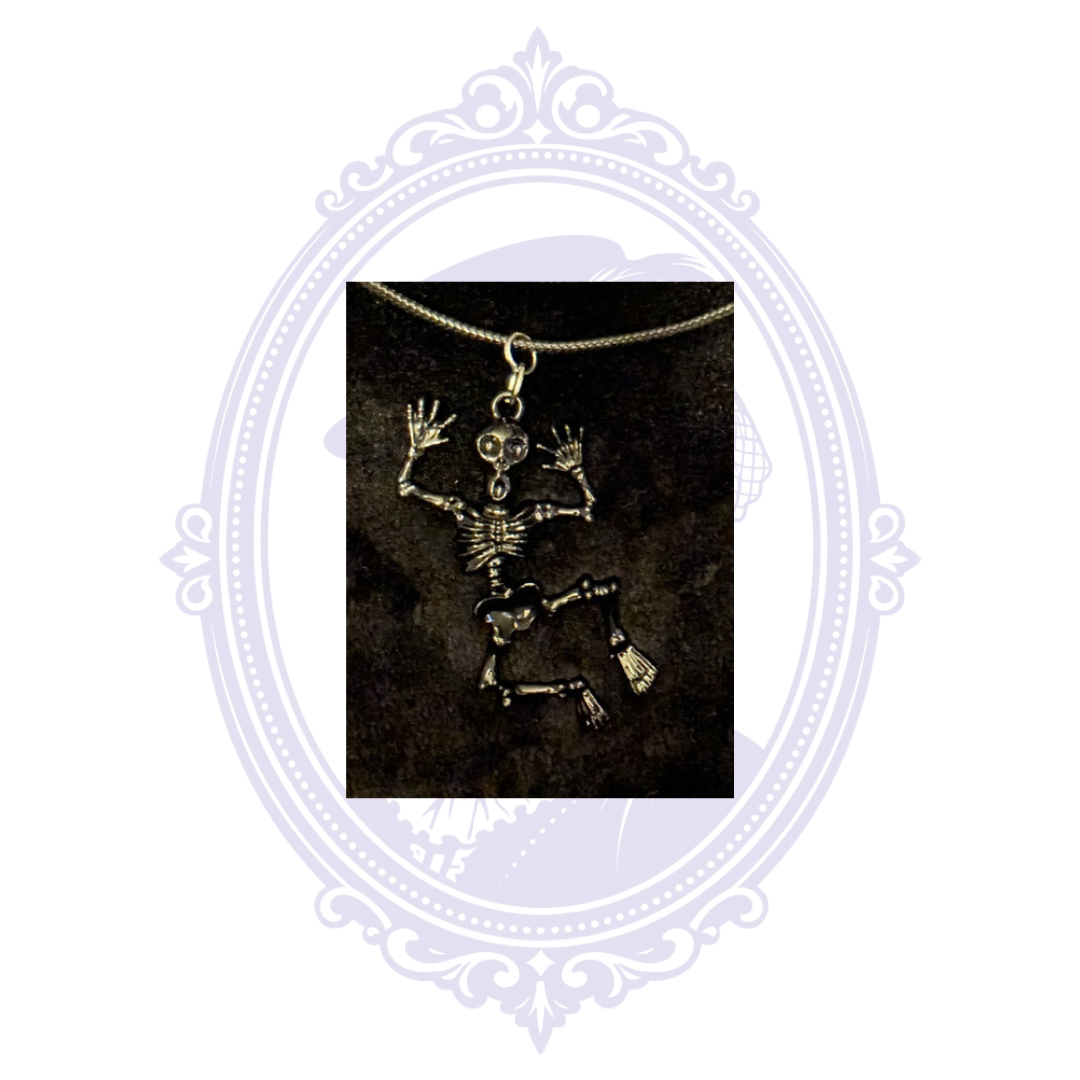 Close-up of the black articulated skeleton pendant showing its jointed arms and legs.