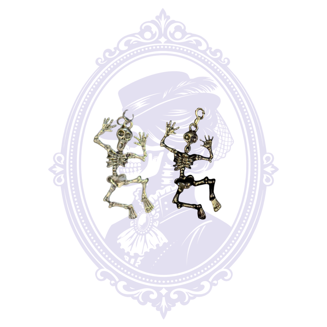 Silver-tone and black articulated skeleton pendants shown together, displaying the two available Cupboard Crafted necklace finishes.