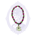 Purple and green glass bead stretch bracelet with gold-tone accents and pale ghost charm, shown in a rounded display.