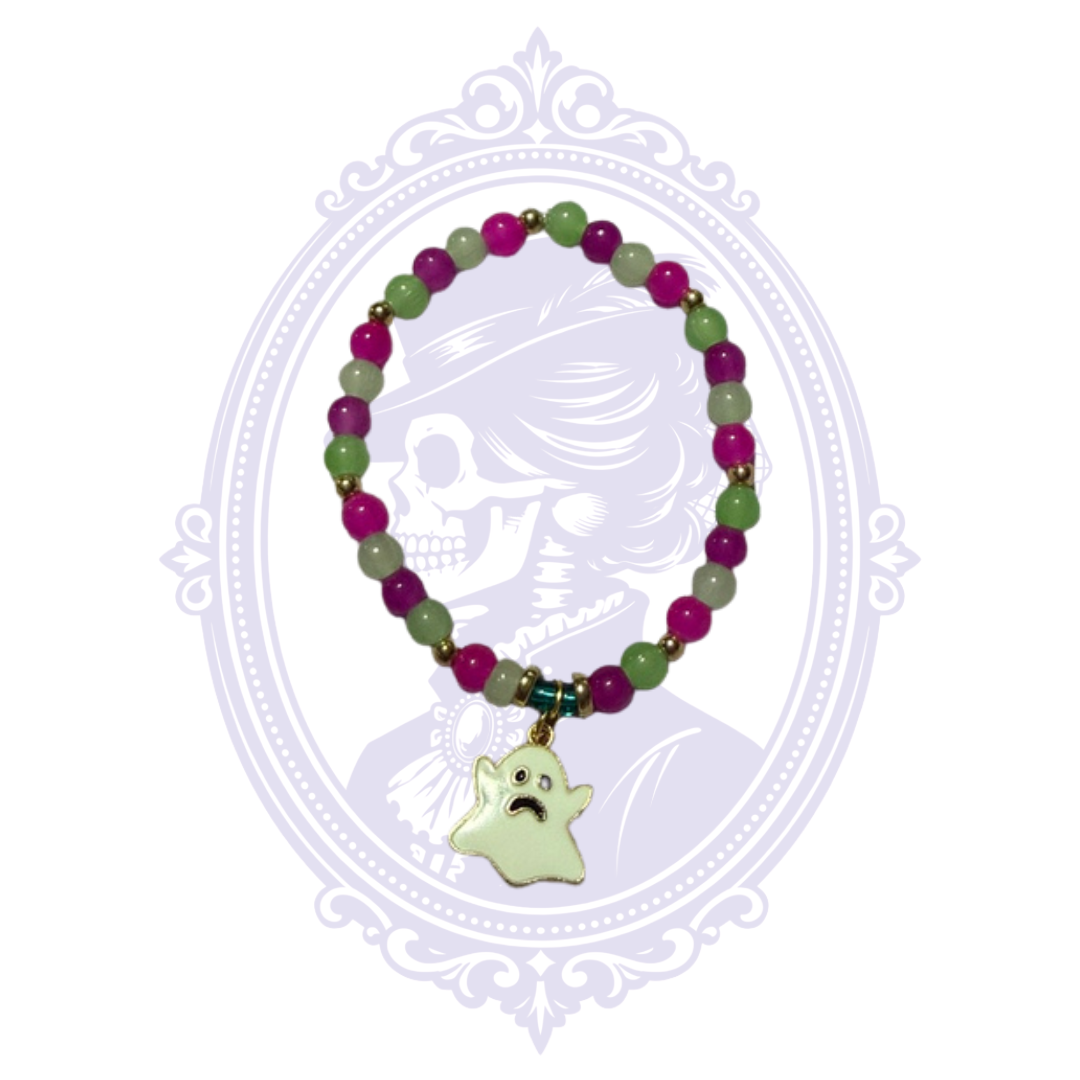 Hand-assembled purple and green glass bead bracelet with gold-tone spacers and pale ghost charm, shown from a slightly different angle.