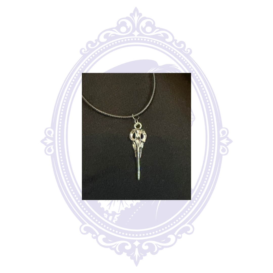 Close-up of detailed silver-tone plague doctor mask pendant hanging from a black cord necklace.