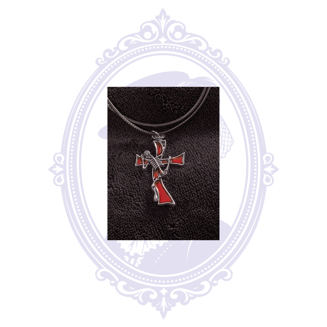 Close-up of silver-tone skeleton musician pendant with red enamel guitar and cross-inspired design.