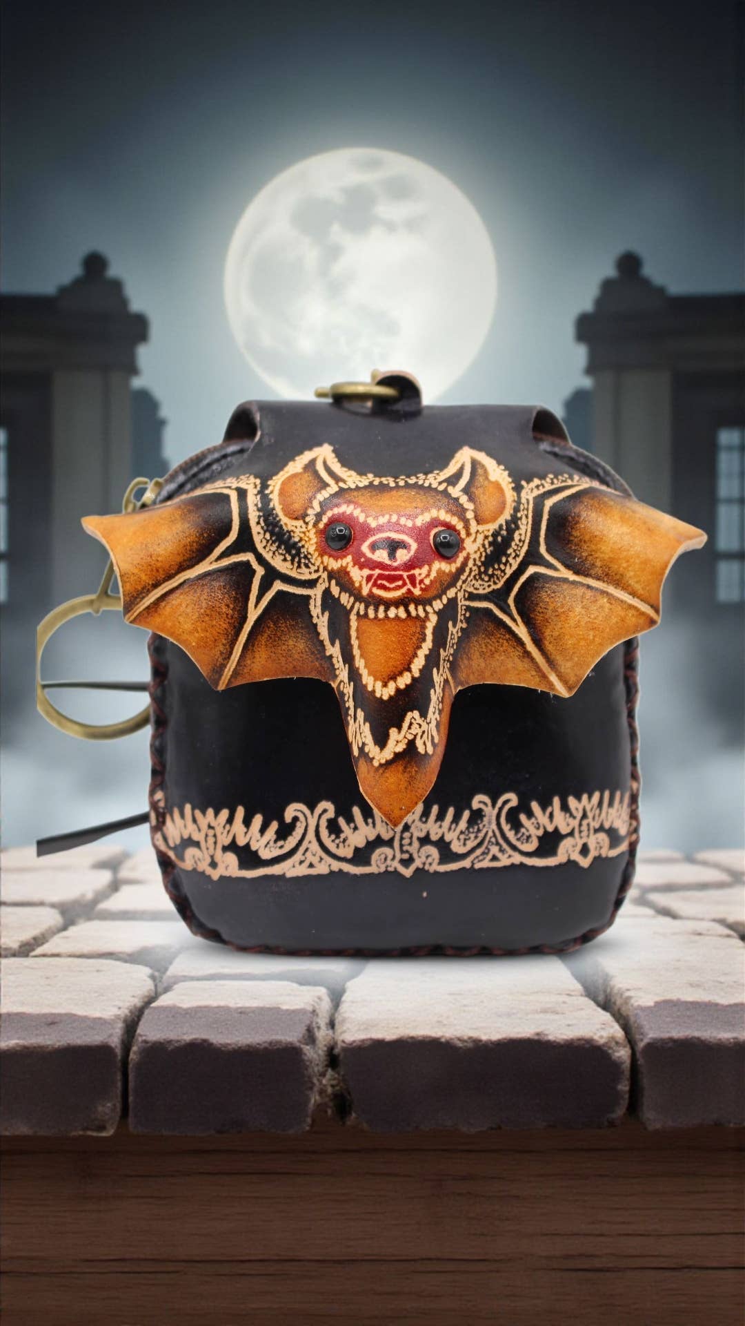Black bag with bat design on a cobblestone street at night.